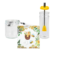 Napkins, a glass-rimmed honey spoon and a glass honey jar with honey dipper are arranged together in a central group.