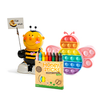 A money box, wax crayons and a Pop-it Fidget Bee are arranged diagonally in front of each other as a group. The objects are very colourful and bright.