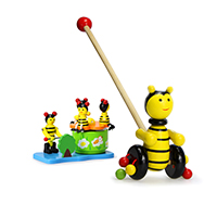 A push bee and a wooden music box are arranged diagonally in front of each other; the wooden items are colourful and childlike