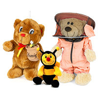 A teddy bear with a honey pot, a teddy bear in a beekeeper's suit and a bee sit together as a group