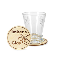 Coaster with burnt bee motif and lettering ‘Imker's Glas’ (Beekeeper's Glass) on the front, with coaster lying behind it with empty glass on top