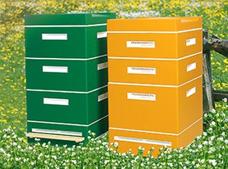 Yellow and green coloured Frankenbeuten are standing in a flowering meadow.