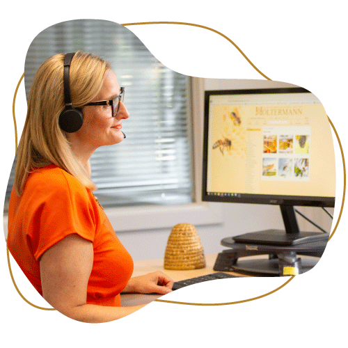 Brauner Klecks mit klecksförmigen Bild davor. Im Klecks ist eine Mitarbeiterin aus dem Kundenservice beim Telefonieren zu sehen