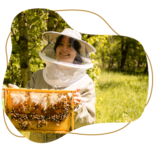 Klecksförmiges Bild Lachende Imkerin hält Wabe mit Bienen im Sonnenschein