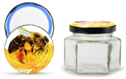 Sechseckglas 106 ml mit 53er Biene, Frontansicht, ein Deckel stehend daneben